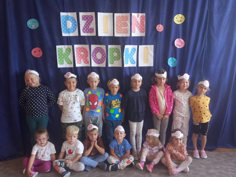Dzieci stoją przy plakacie